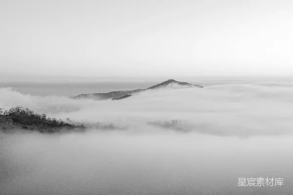 高清摄影 一张黑白照片，展示了雾蒙蒙的山峰。