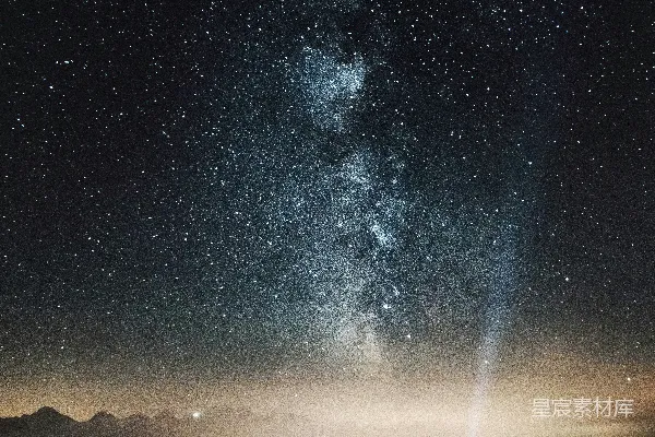 高清摄影 一个人站在山顶上，手里拿着手电筒，对着满天繁星的夜空指去。