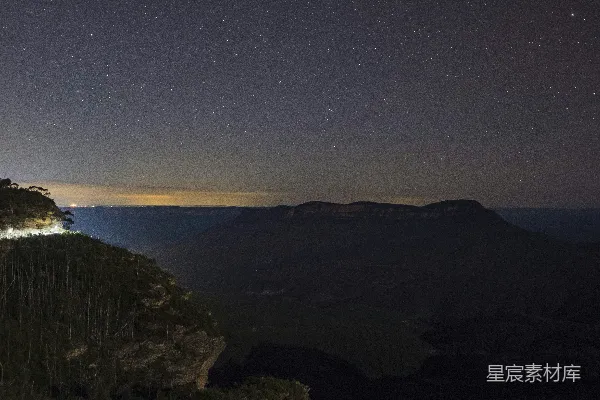 高清摄影 夜晚山间的景色，天空中有星星闪烁。