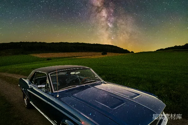 高清摄影 一辆汽车停在泥泞的小路上，在星空满天的夜空下。