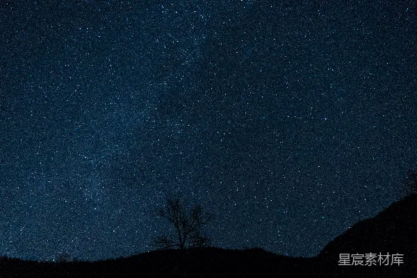 高清摄影 夜空中的星星在一座小山上空