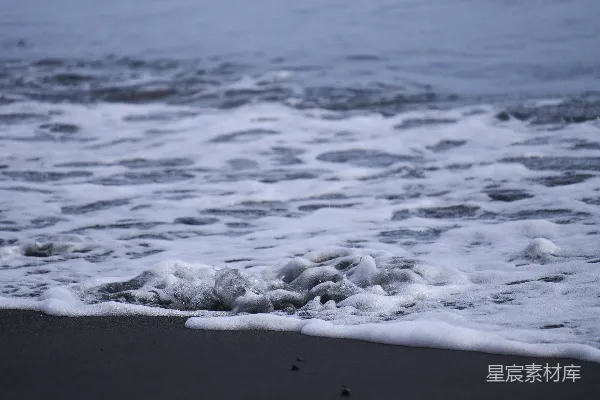 高清摄影 海浪拍打着黑暗的沙滩。