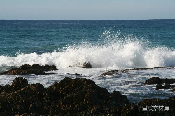 高清摄影 海浪在晴朗的天空下拍打着岩石海岸。