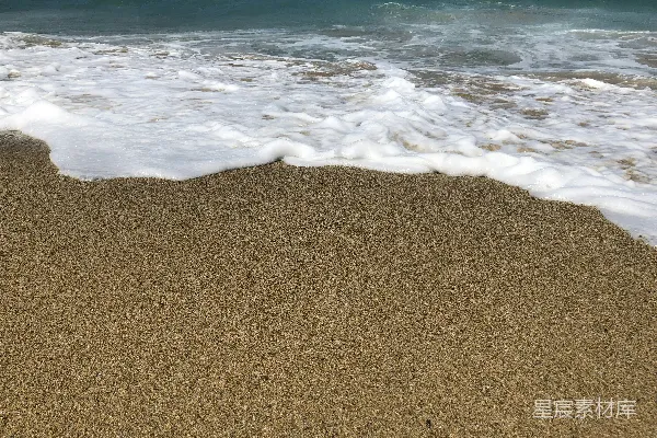 高清摄影 一个沙滩，海浪正拍打着岸边。