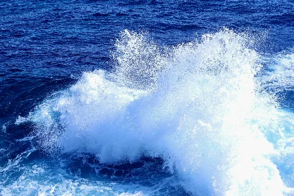 高清摄影 一股巨大的海浪冲向蓝色的海洋，激起白色的浪花。