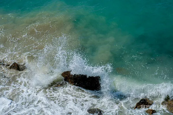 高清摄影 海浪拍打着岩石海岸，海水清澈湛蓝。