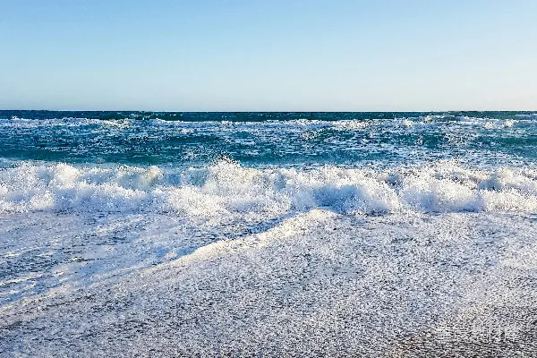 高清摄影 一个沙滩，海浪拍打着岸边。