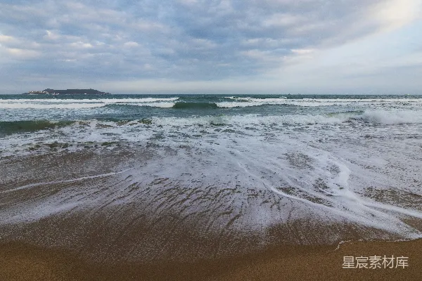 高清摄影 一个海滩，海浪在水中进进出出。