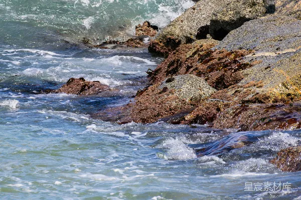 高清摄影 海浪拍打着岩石海岸，激起白色的泡沫。