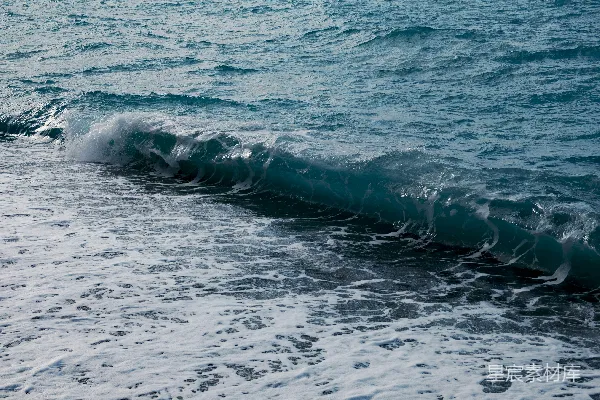 高清摄影 海浪拍打着鹅卵石海滩，激起白色泡沫。