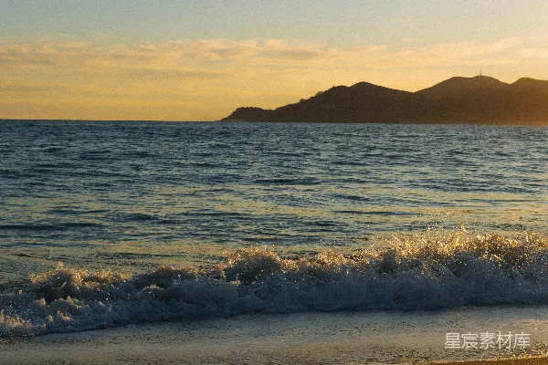 高清摄影 夕阳下，海浪拍打着沙滩。