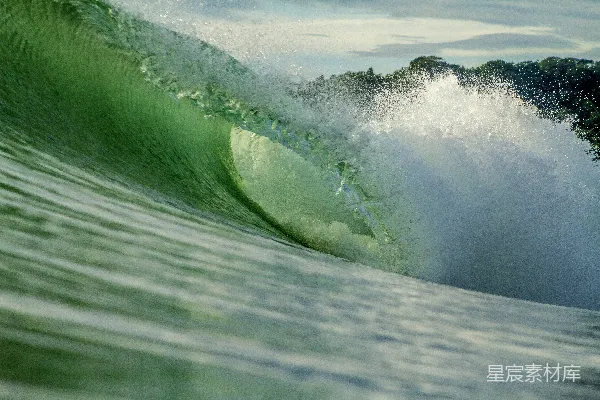 高清摄影 一个巨大的海浪正砸在一块绿色冲浪板上。
