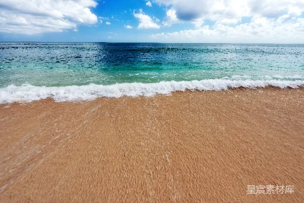 高清摄影 一个沙滩，海浪涌向岸边。