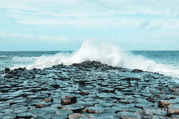 高清摄影 海浪拍打在海边六边形岩石上。