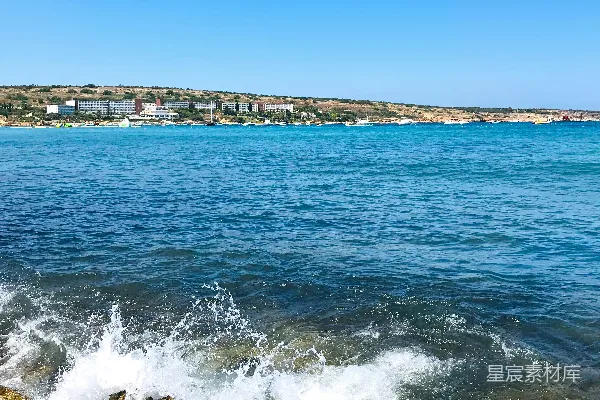 高清摄影 白天，蓝色天空下海浪拍打着岩石。