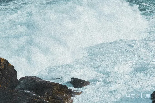高清摄影 一个男人站在岩石上，看着暴风雨中的海浪。