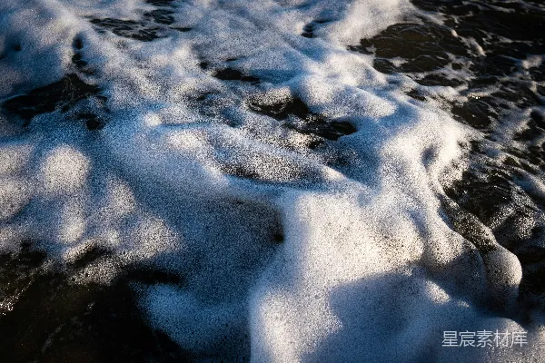 高清摄影 一个被雪覆盖的海滩紧挨着海洋。