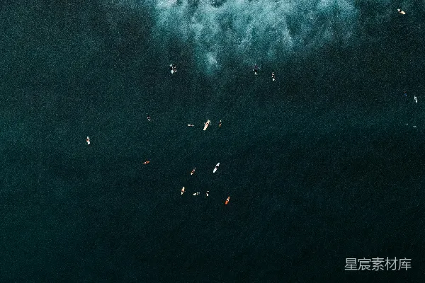 高清摄影 冲浪者在深蓝色的大海中等待海浪。