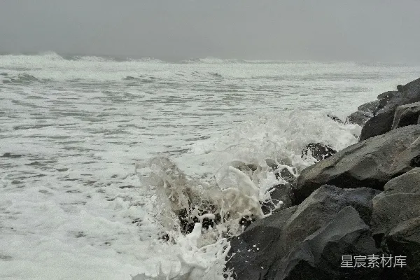 高清摄影 在雾蒙蒙的天气里，海浪撞击岩石。