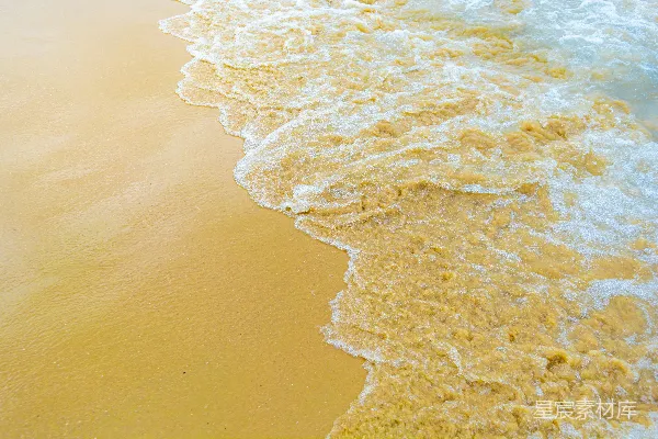高清摄影 一个海滩，波浪正朝着岸边涌来。