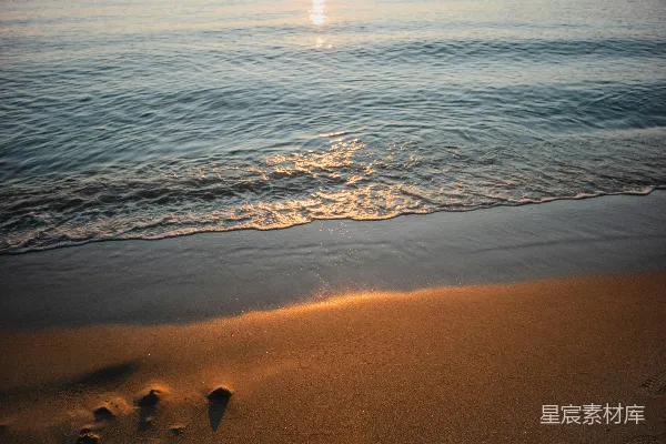 高清摄影 夕阳下，温柔的海浪拍打着沙滩。