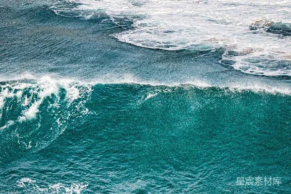 高清摄影 两个冲浪者在碧蓝的海水中等待，波浪拍打着海岸。
