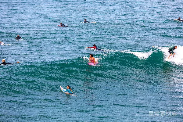 高清摄影 一群人在海浪上骑着冲浪板。