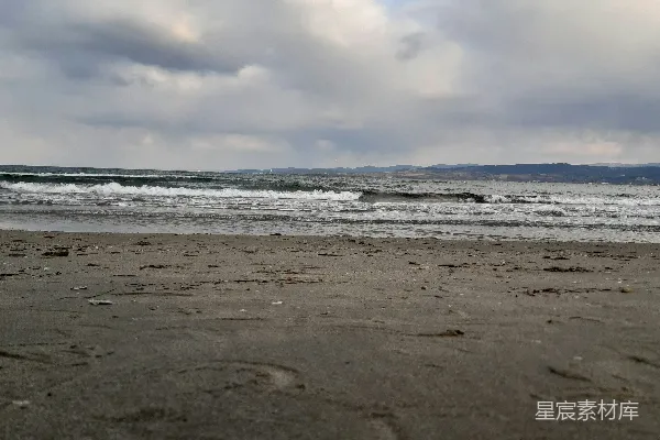 高清摄影 一个沙滩，海浪冲向岸边。