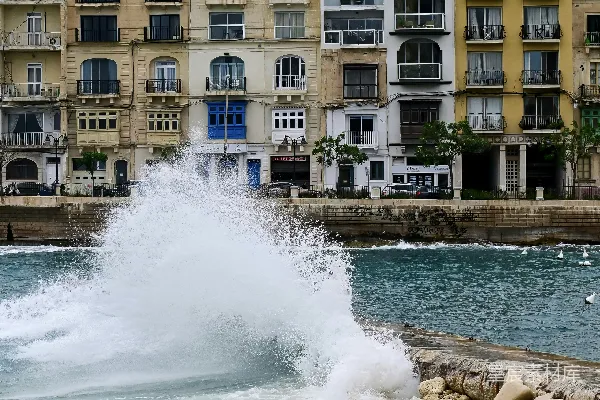 高清摄影 一个巨大的海浪冲向城市的海边。