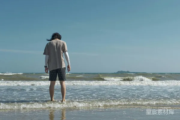 高清摄影 一个人站在海滩的水中。