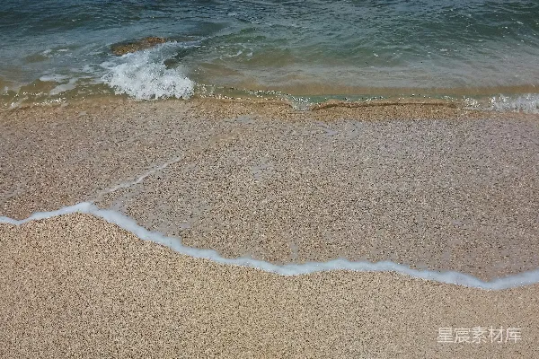高清摄影 一个沙滩上，海浪在水中进出。