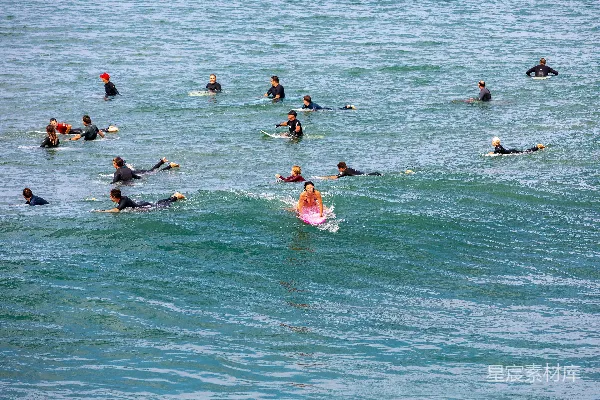高清摄影 一群人在海浪上骑着冲浪板。
