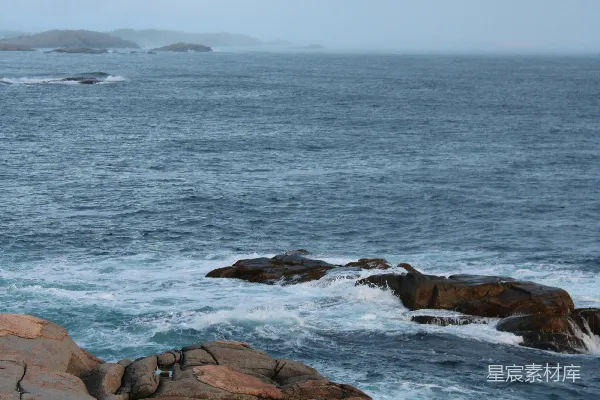 高清摄影 站在岩石海滩上，面对大海的人