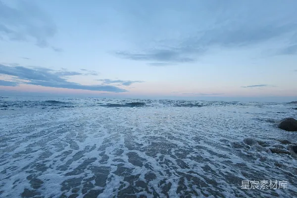 高清摄影 一个沙滩，海浪拍打着岸边。