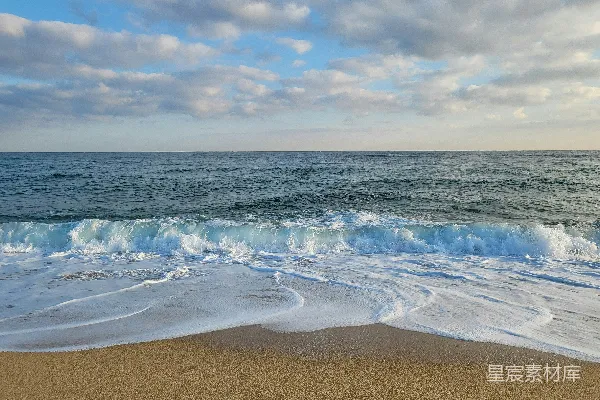 高清摄影 一个沙滩上，海浪拍打着海岸线。