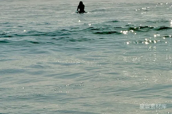 高清摄影 一个孤独的冲浪者坐在冲浪板上，漂浮在海中。