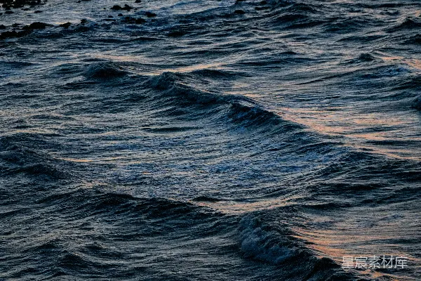 高清摄影 深海波涛，夕阳微光映照。