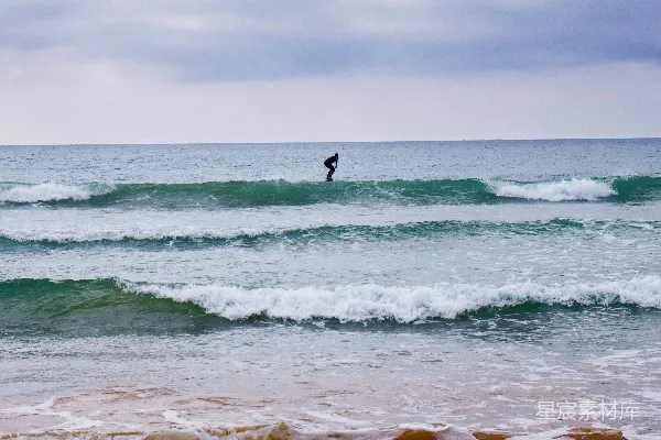 高清摄影 在白天，一个人在海浪上冲浪。