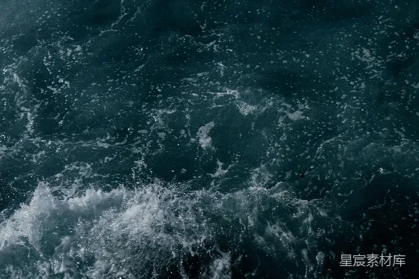 高清摄影 一个男人骑在冲浪板上，站在海浪顶上。