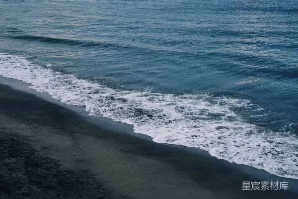 高清摄影 海浪拍打着黑暗的沙滩。