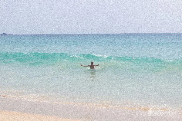 高清摄影 一个人在海里拿着冲浪板。