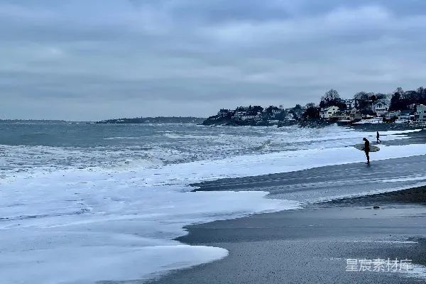 高清摄影 一个人在海滩上拿着冲浪板。