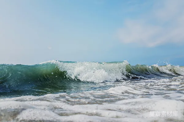 高清摄影 海浪拍打着沙滩，天空湛蓝。