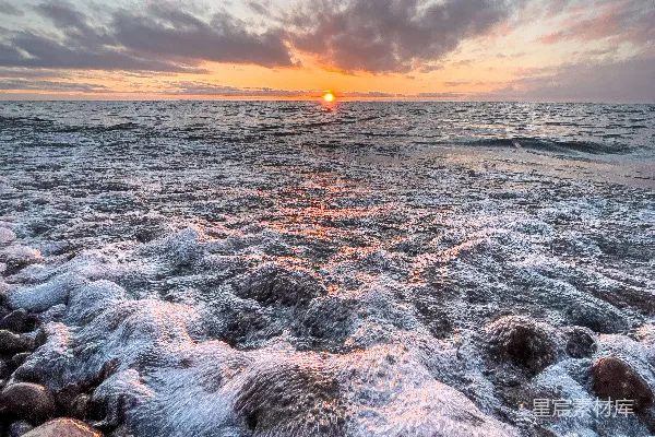 高清摄影 在多云的天空下，夕阳下的岩石海岸