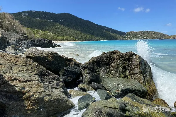 高清摄影 岩石海岸，远处有青山，天空湛蓝，白天景色。