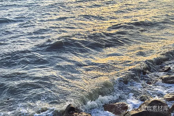 高清摄影 一个人坐在岩石旁，面对着大海。
