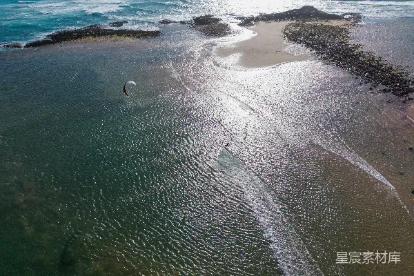高清摄影 风筝冲浪者在岸边附近的浅海水中滑行