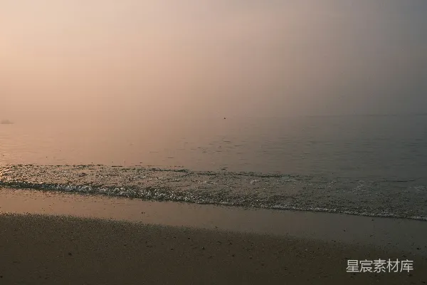 高清摄影 日出时分，柔和的海浪拍打着沙滩。