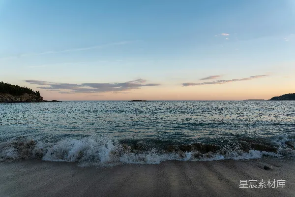 高清摄影 夕阳西下，海浪轻轻地拍打着沙滩。