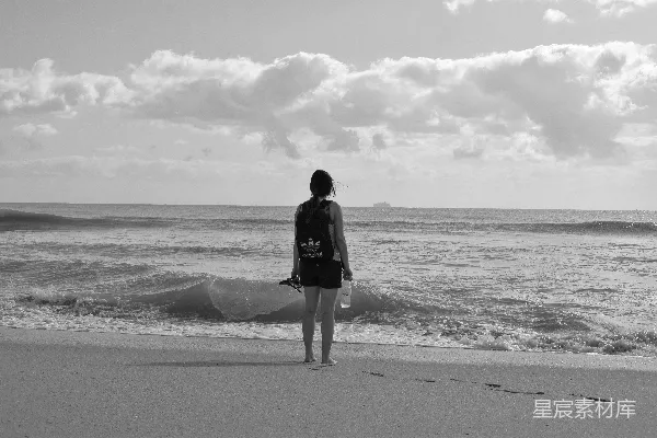 高清摄影 女人站在海边，背对着镜头。